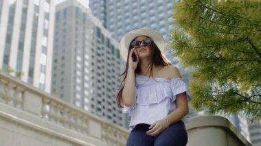 Talking, cep telefonu üzerinde taş çit oturan genç bir kadına ait