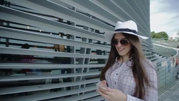 Woman is Walking on Street in Sunny Summer Day and Talking on Phone. — Stock video