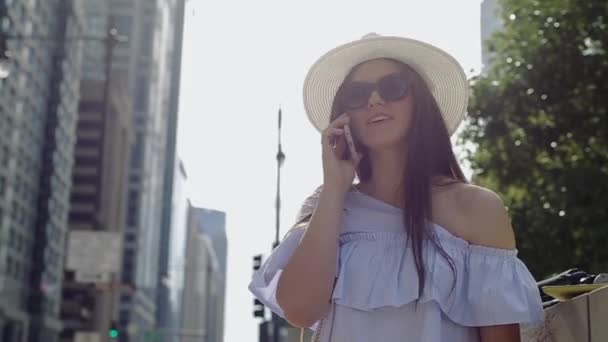 Mulher elegante fica na rua de verão cercado com edifícios de alta ascensão . — Vídeo de Stock