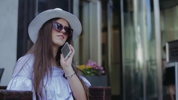 Belle femme assise sur la rue dans une chaise en bois tressé . — Video