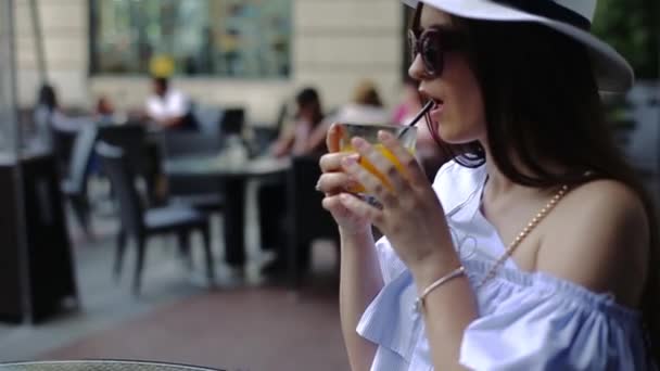 Charming Young Lady Enjoys Drinking Orange Juice From Black Plastic Tube. — Stock Video