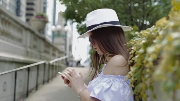 Mulher bonita está trabalhando com celular em pé fora no beco . — Vídeo de Stock