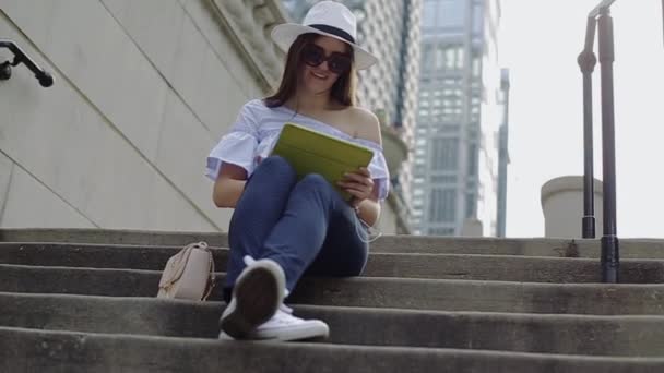Mulher bonita está trabalhando com tablet pc sentado em escadas de rua . — Vídeo de Stock