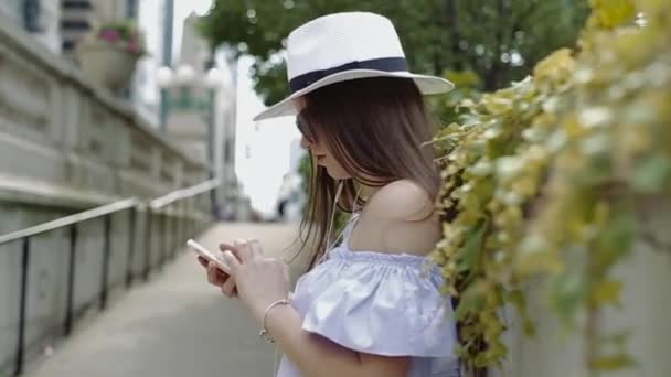 Mulher bonita está trabalhando com celular em pé fora no beco . — Vídeo de Stock