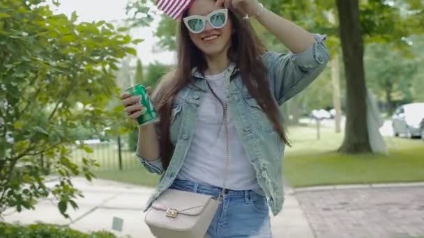 Junge Frau spaziert durch Park und feiert Unabhängigkeitstag. — Stockvideo