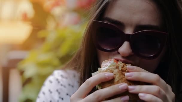 Hermosa chica come hamburguesa en la calle en Chicago — Vídeo de stock