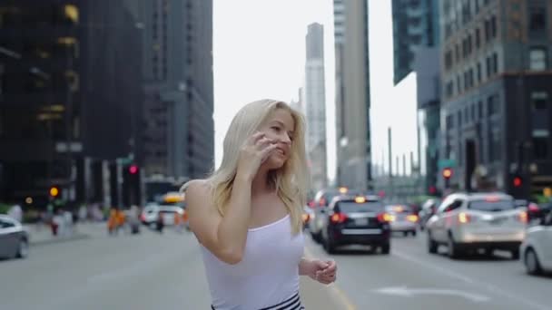 Chica joven con el pelo blanco que fluye corre en medio de la carretera donde los coches viajan y hablan por teléfono . — Vídeo de stock