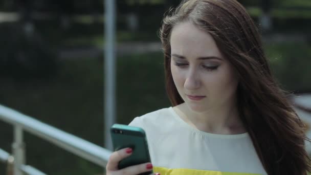 Fiatal lány tárcsázza a számot, a mobil telefon, és komolyan beszél. — Stock videók