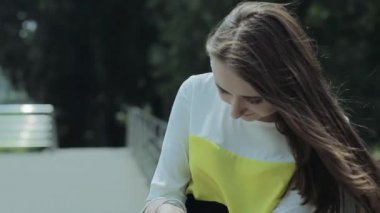 Genç bir kız sokakta duran ve cep telefonu kılıfı seyir.