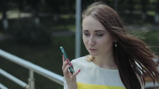 Young Girl Dials the Number on Your Mobile Phone and Speaks Seriously. — Stock Video