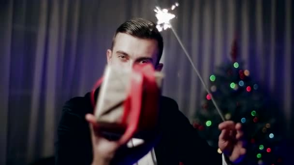 A Young Guy With Sparklers Presents Packed Gift. — Stock Video