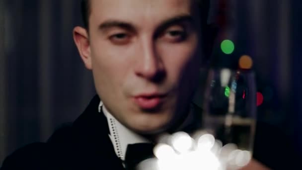 A Young Man Holding a Sparkler and Drinks a Glass of Champagne. Close Up. — Stock Video