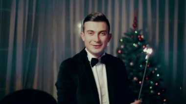 havai fişekleri ile Noel ağacı yakınındaki mevcut elleri genç bir adam atar.