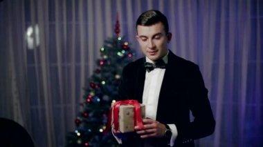 Noel ağacı, odada duran genç bir çocuk diyor tebrik ve genişleten küçük bir hediye sarılmış.