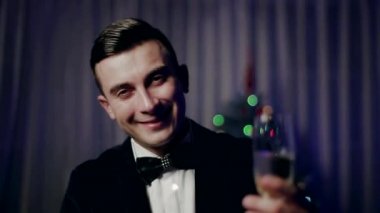 bir bardak şampanya ve selamlar Noel ağacı, bağırarak havai fişekleri ile genç bir adam.