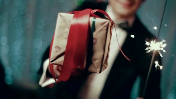 Τύπος χριστουγεννιάτικα δώρα σε συσκευασία που κρατά ο άνθρωπος σε ένα κοστούμι. — Αρχείο Βίντεο