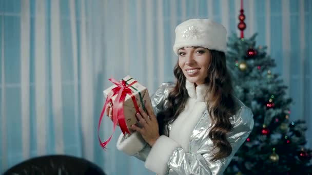 Jovem donzela de neve segurando um presente e sorrindo, alegrando-se . — Vídeo de Stock
