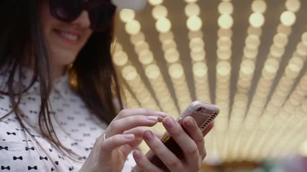 Jonge vrouw in hoed en bril, gloeiende ingang Hotel en praten over de telefoon Slow Motion. — Stockvideo