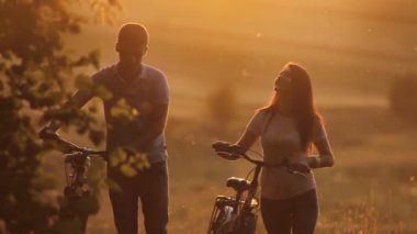 Bisiklet üzerinde günbatımı güzel çiftle