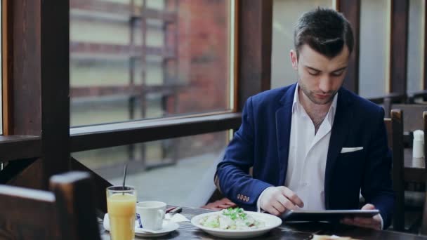 Бизнесмен работает на планшете на ужин — стоковое видео