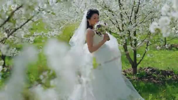 Noiva com um buquê de flor no jardim — Vídeo de Stock