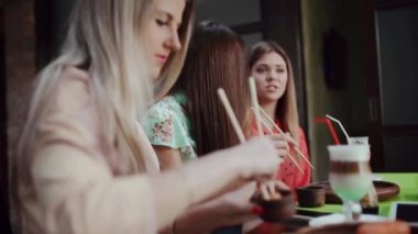 Kız bir Cafe latte ve kızlarla suşi yiyor