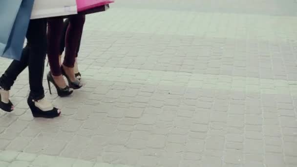 Three beautiful girls with shopping bags in shop — Stock Video