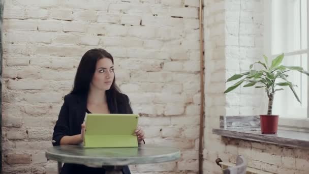 Dijital tablet ve kapuçino ahşap bir masa üzerinde tutan adam — Stok video