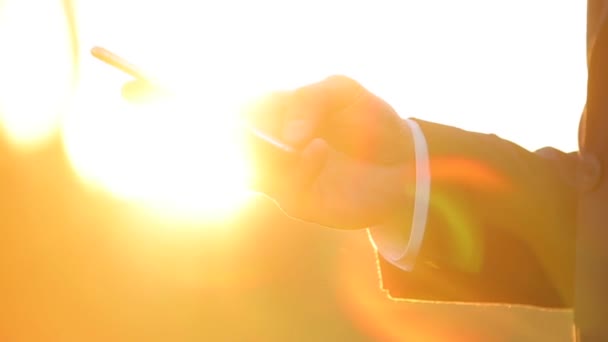 Erfolgreicher Geschäftsmann, der mit dem Telefon durch das Sonnenlicht arbeitet. — Stockvideo