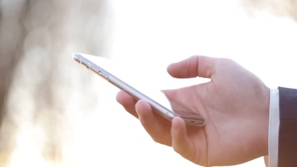 Homme d'affaires prospère travaillant avec le téléphone, à travers la lumière du soleil . — Video