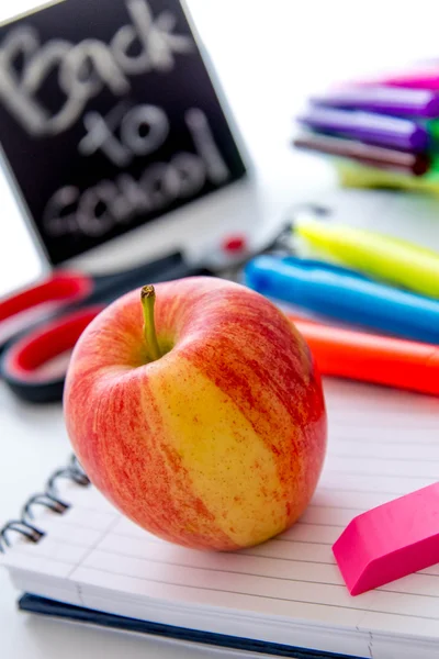 back to school supplies and an apple for the teacher