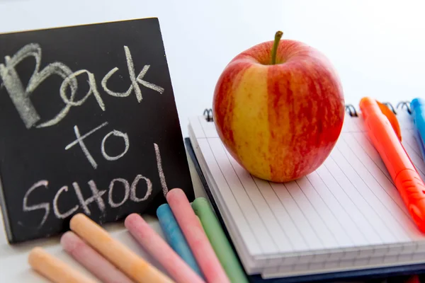 back to school supplies and an apple for the teacher