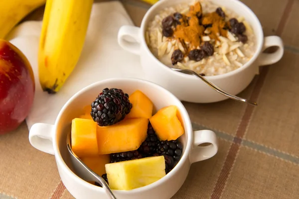 Fresh fruit and oatmeal with healthy toppings for breakfast — Stock Photo, Image
