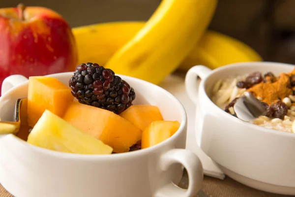 Свіжі фрукти та вівсянка зі здоровими начинками на сніданок — стокове фото
