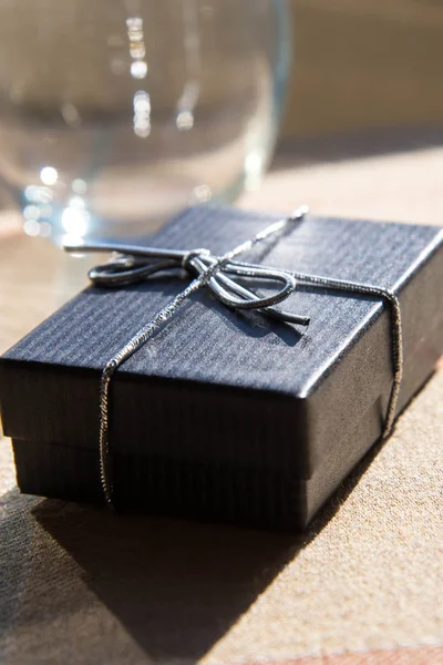 small gift box with a silver bow in morning sunlight