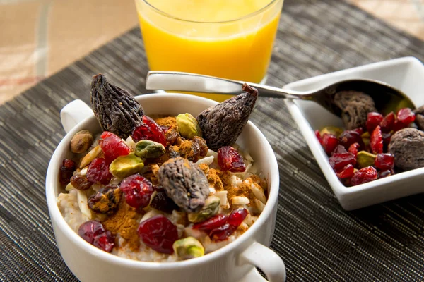 Desayuno saludable harina de avena con frutas secas y coberturas de frutos secos — Foto de Stock