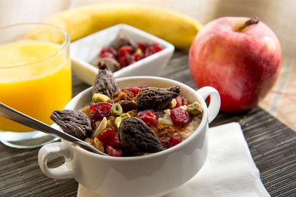 Fresh fruit and oatmeal with healthy toppings for breakfast — Stock Photo, Image