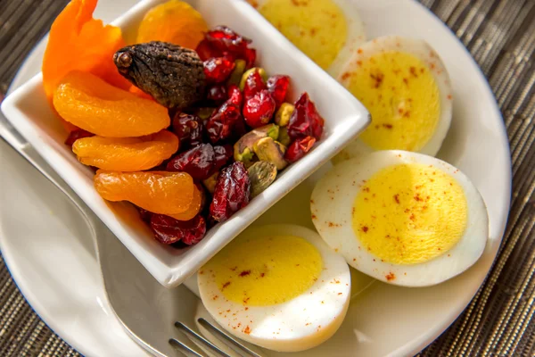 Skivede hårdkogte æg og frugt nærende morgenmad - Stock-foto