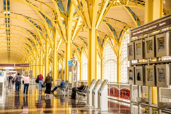 Passagiere gehen durch einen hellen Flughafen — Stockfoto