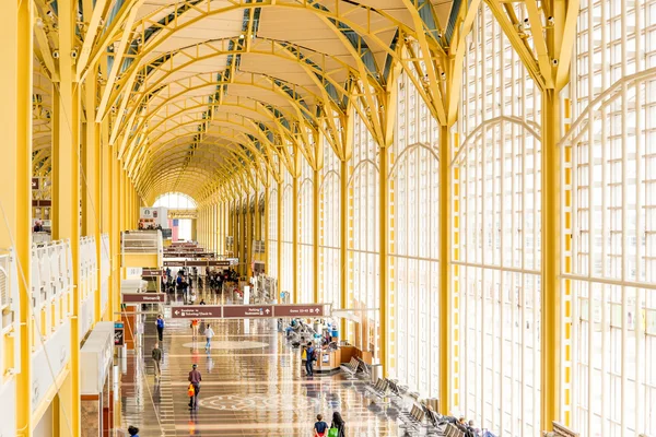 Passeggeri che attraversano un aeroporto luminoso — Foto Stock