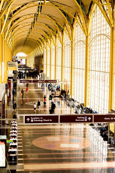 Passengers walking through a bright airport — Stock Photo, Image
