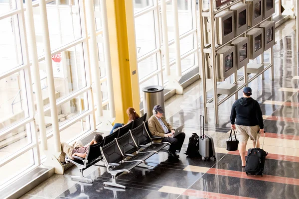 Passageiros esperando na frente de uma janela do aeroporto interior brilhante — Fotografia de Stock