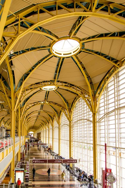 Passagiers lopen via een heldere luchthaven — Stockfoto