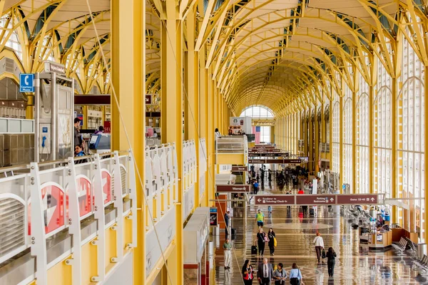 Passagiere gehen durch einen hellen Flughafen — Stockfoto