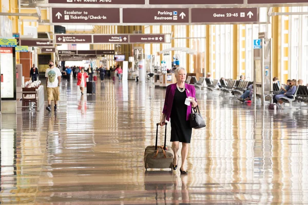 Passengers walking through a bright airport — Stock Photo, Image