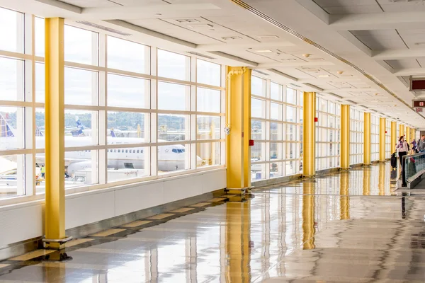 Passagiers lopen via een heldere luchthaven — Stockfoto