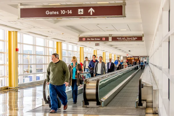 Personas en una pasarela en movimiento en un aeropuerto brillante —  Fotos de Stock