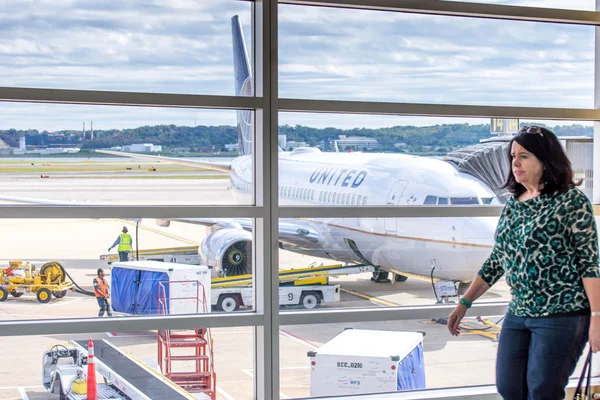 Pasagerul mergând în fața unei ferestre a aeroportului cu vedere la p — Fotografie, imagine de stoc