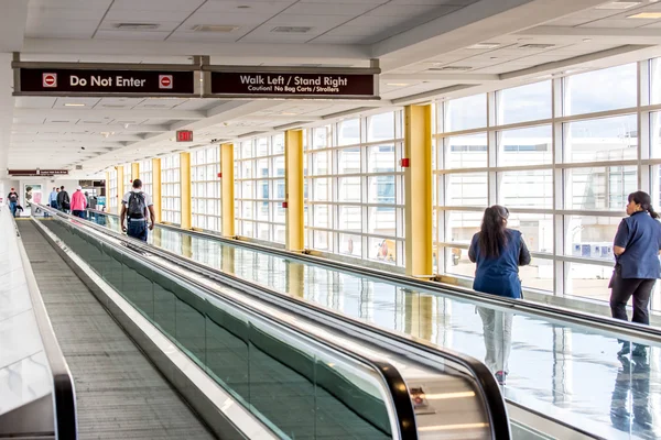 Passengers walking through a bright airport — Stock Photo, Image