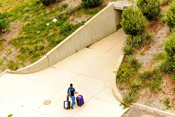 Persona a piedi con i bagagli al parcheggio all'aperto — Foto Stock